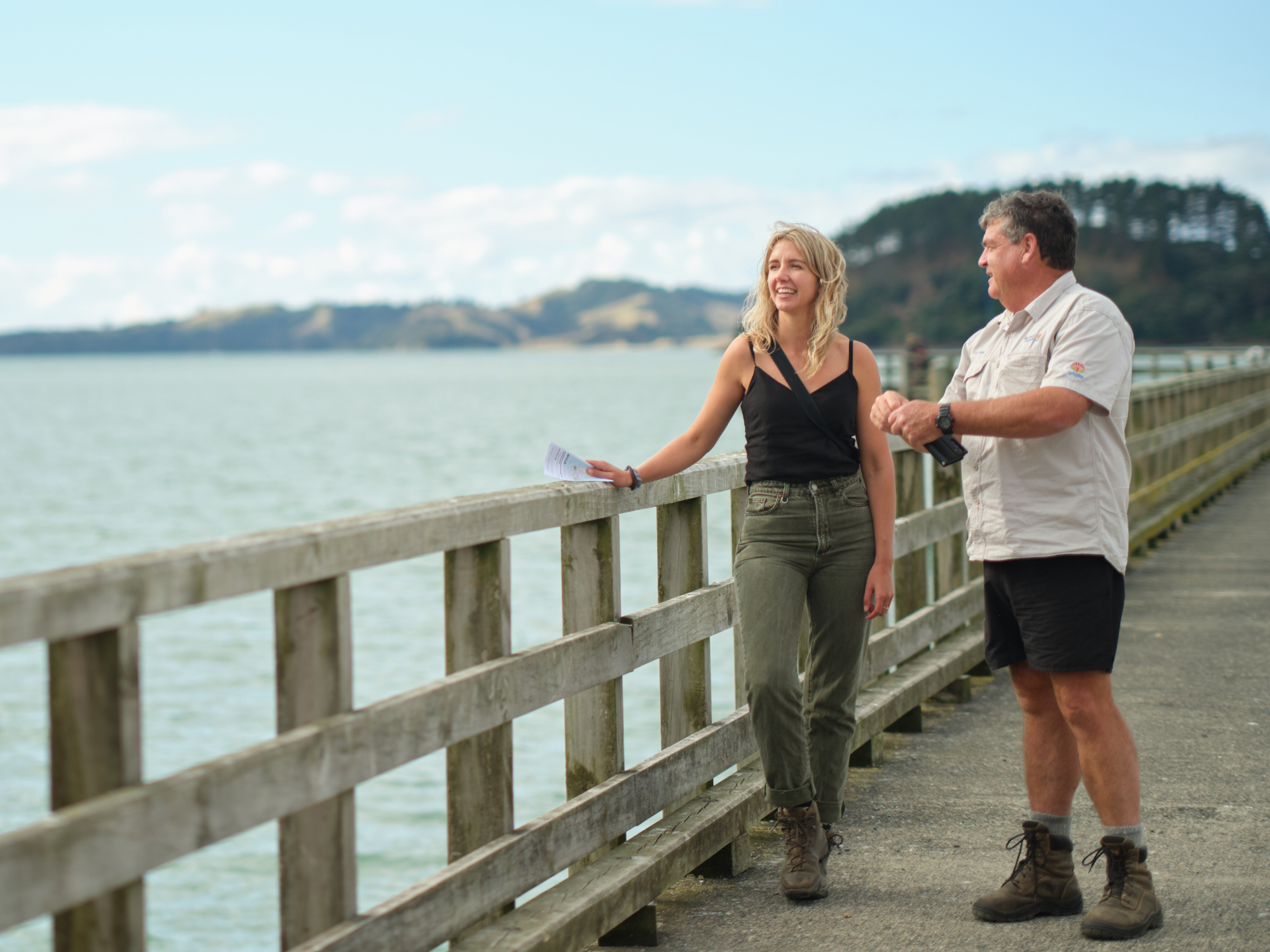 Kate and park ranger on a boardwalk next to the ocean.