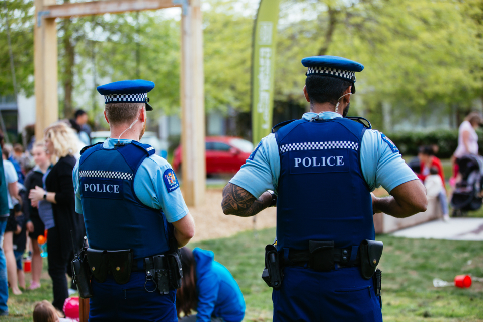 Two policemen stand watching over a park