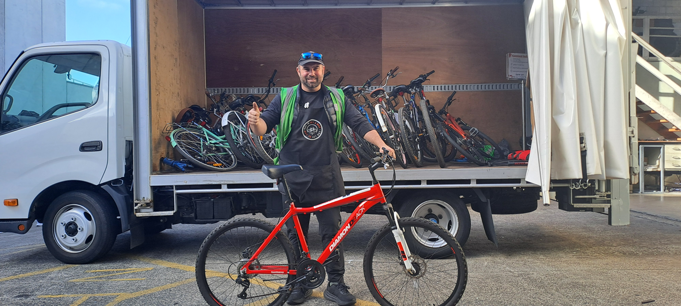 A man next to a collection of bikes.