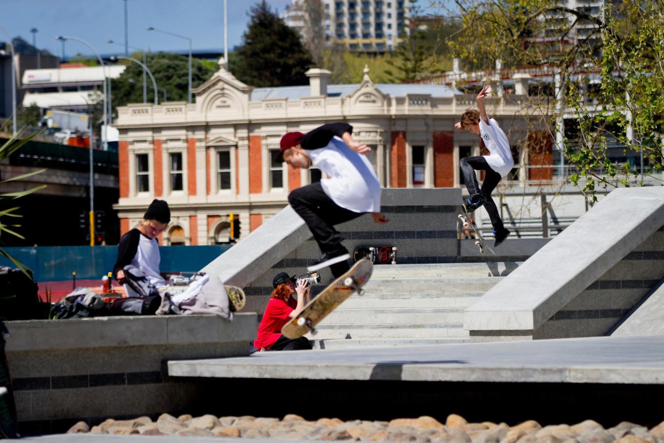 Youth skateboarding in a skate park with a photographer taking pictures