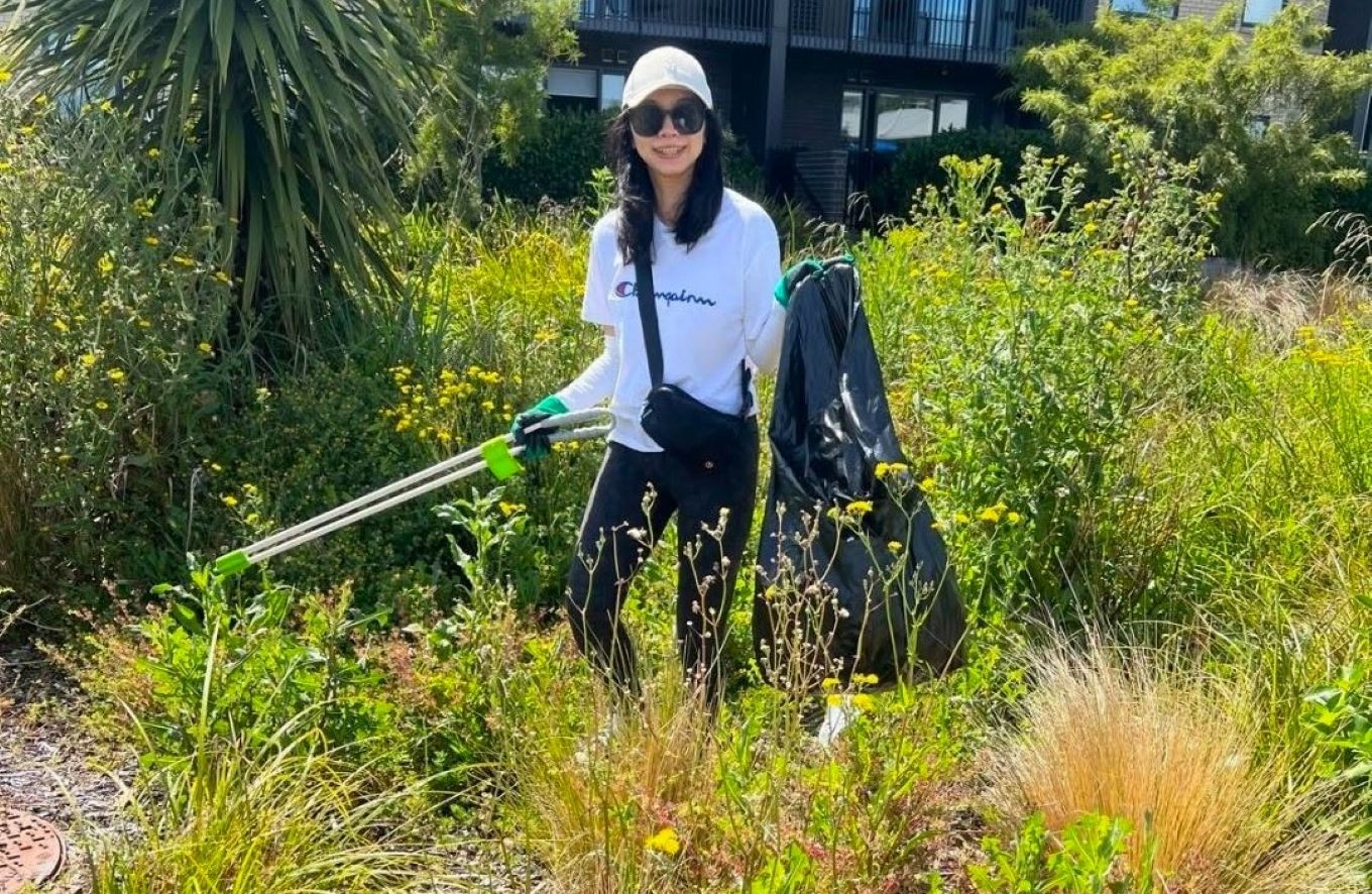 A local volunteering picking up rubbish in a bush area. 