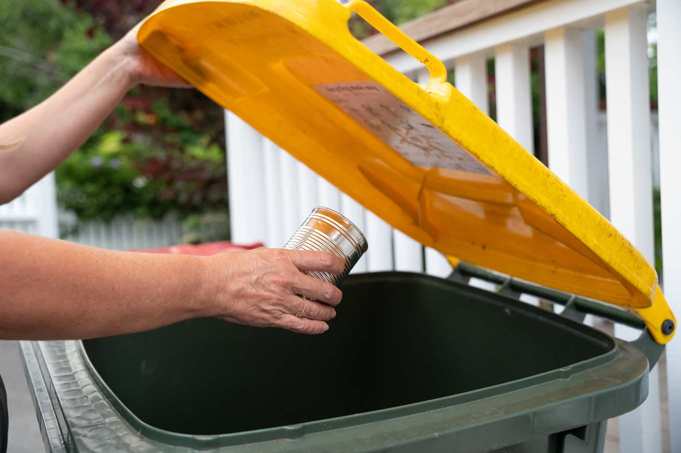 A can going into the recycling bin. 
