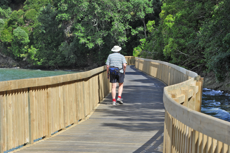 A man walking on a boardwalk.