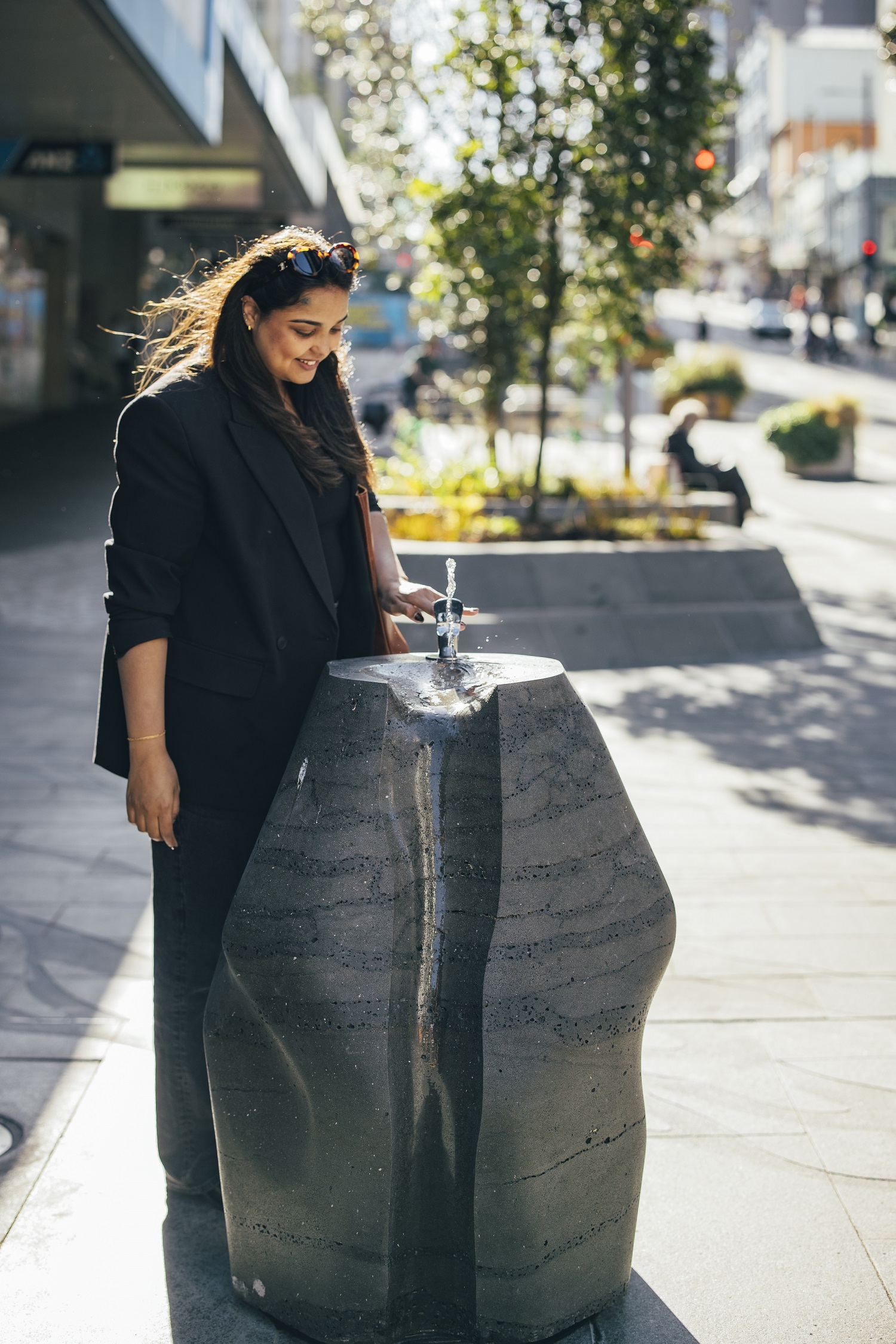 Pedestrian enjoying new drinking fountain.