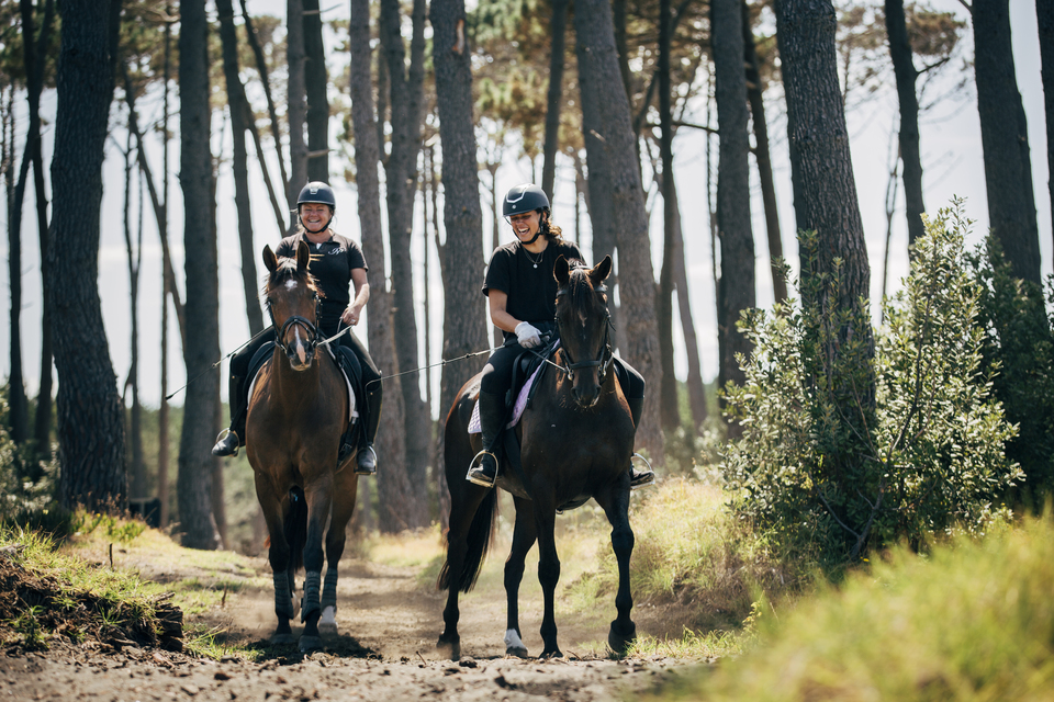 Two young women riding horses. 