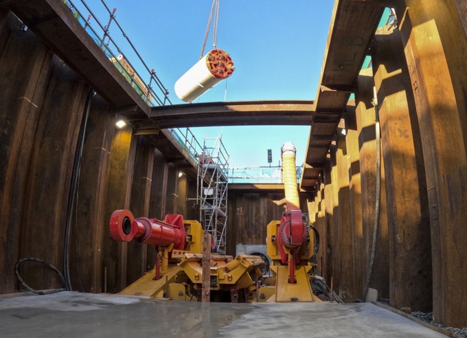 The Tunnel Boring Machine (TBM) is lowered into the launch site by crane.