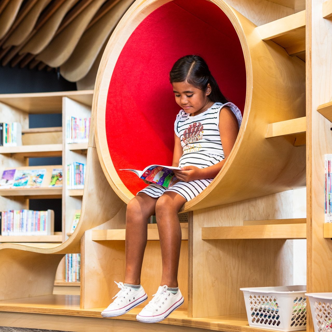 A girl reading at Te Manawa Library. 
