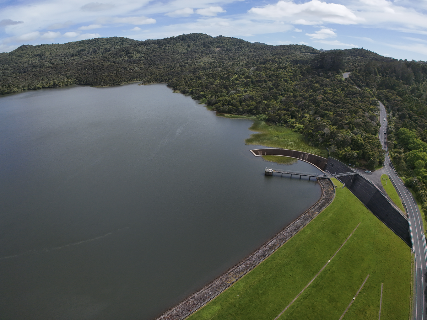 An aerial shot of a completly filled local dam. 