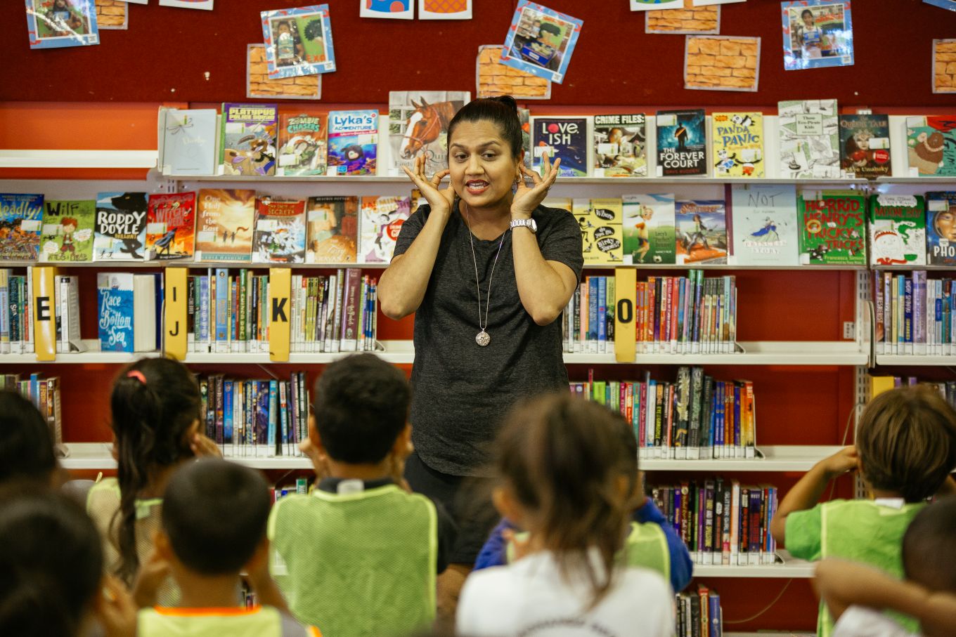A lady teaching children sign language at a local library. 