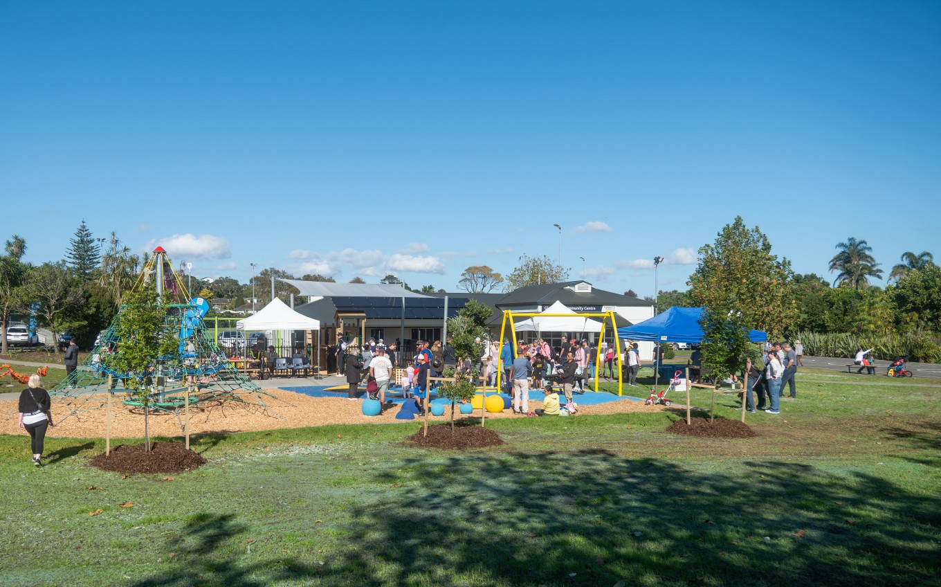 A colourful playground with children playing on it surrounded by grass